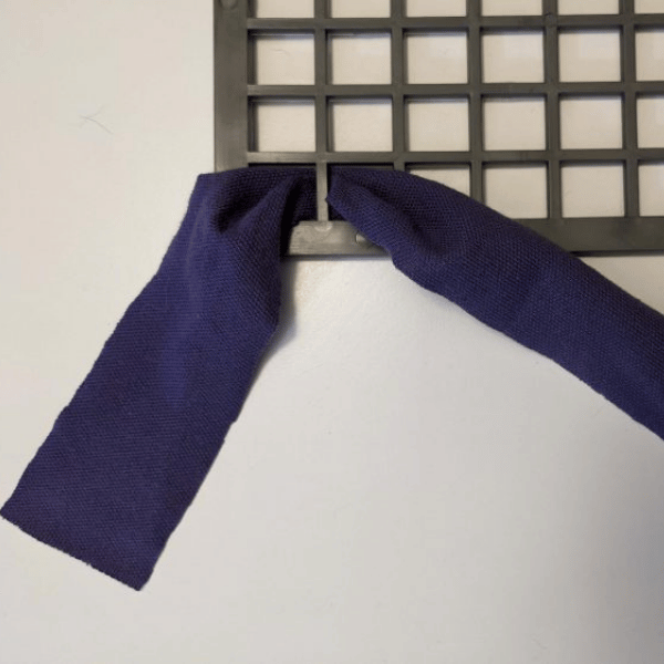 Photo of a strip of fabric being fed through the rubber mat