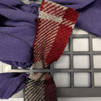 Photo of a strip of fabric fed through the rubber mat and being tied