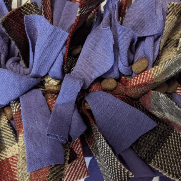 Photo of a strip of fabric fed through the rubber mat and being tied