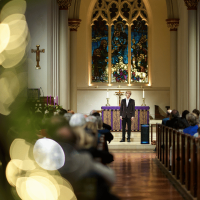 Photo of man performing a song in a church