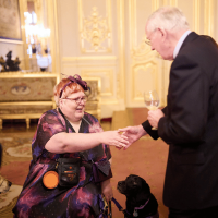 The Duke of Gloucester greeting a Canine Partners partner and their assistance dog at the Windsor Castle event