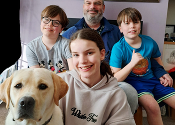 Family of three children, Dad and Brood labrador