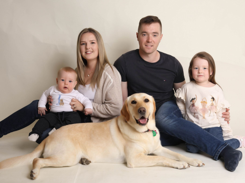 Photo of family mum dad two children and a yellow labrador at the front