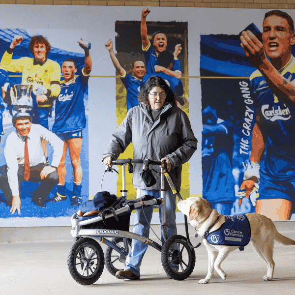 Photo of assistance, dog and partner walking through the club shop